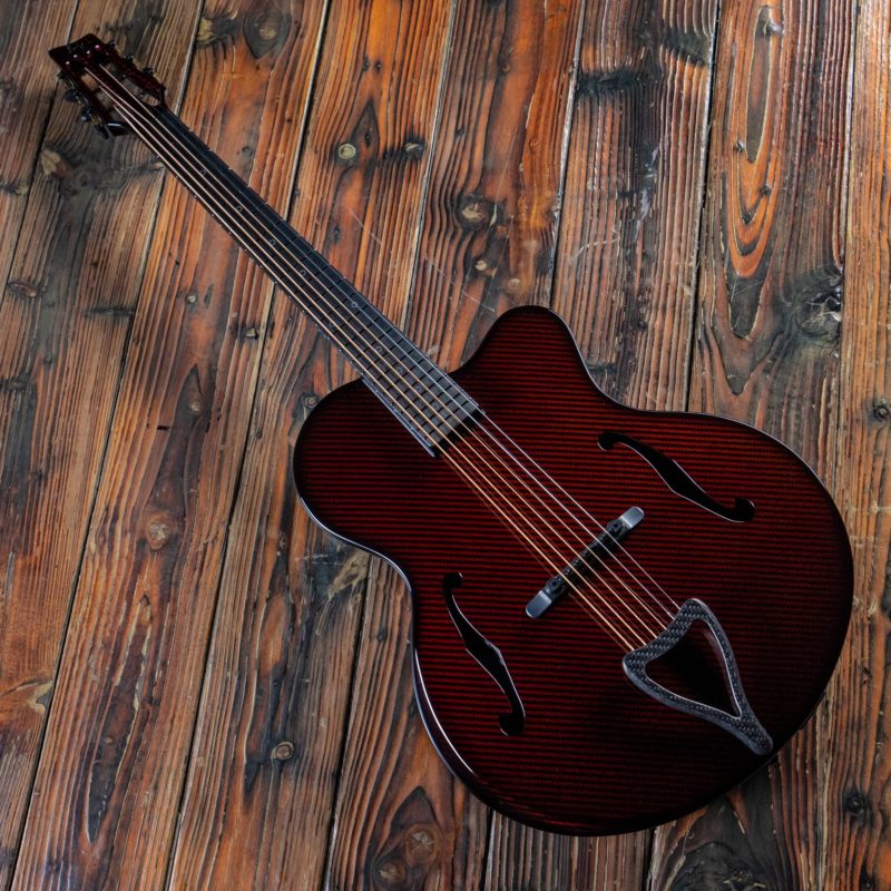 Red Emerald Kestrel Guitar on Wooden Background