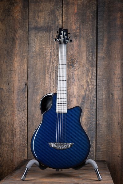 Frontal view of Emerald X7 carbon fiber guitar in blue displayed on stand
